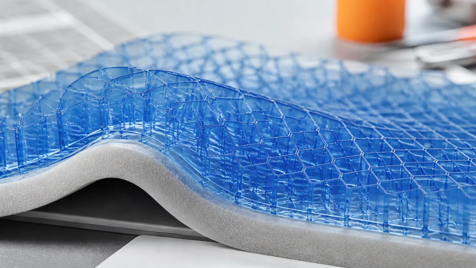 Transparente blaue Gelstruktur auf einem neutralen Schaumkern in technischer Nahaufnahme
